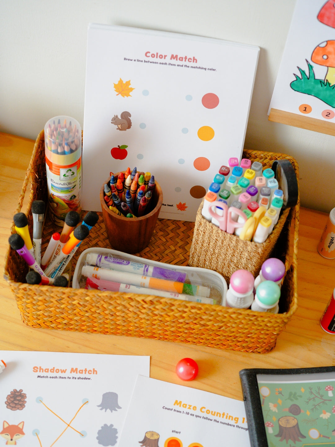 Colorful stationery items including markers, crayons, and a book on a wooden surface.