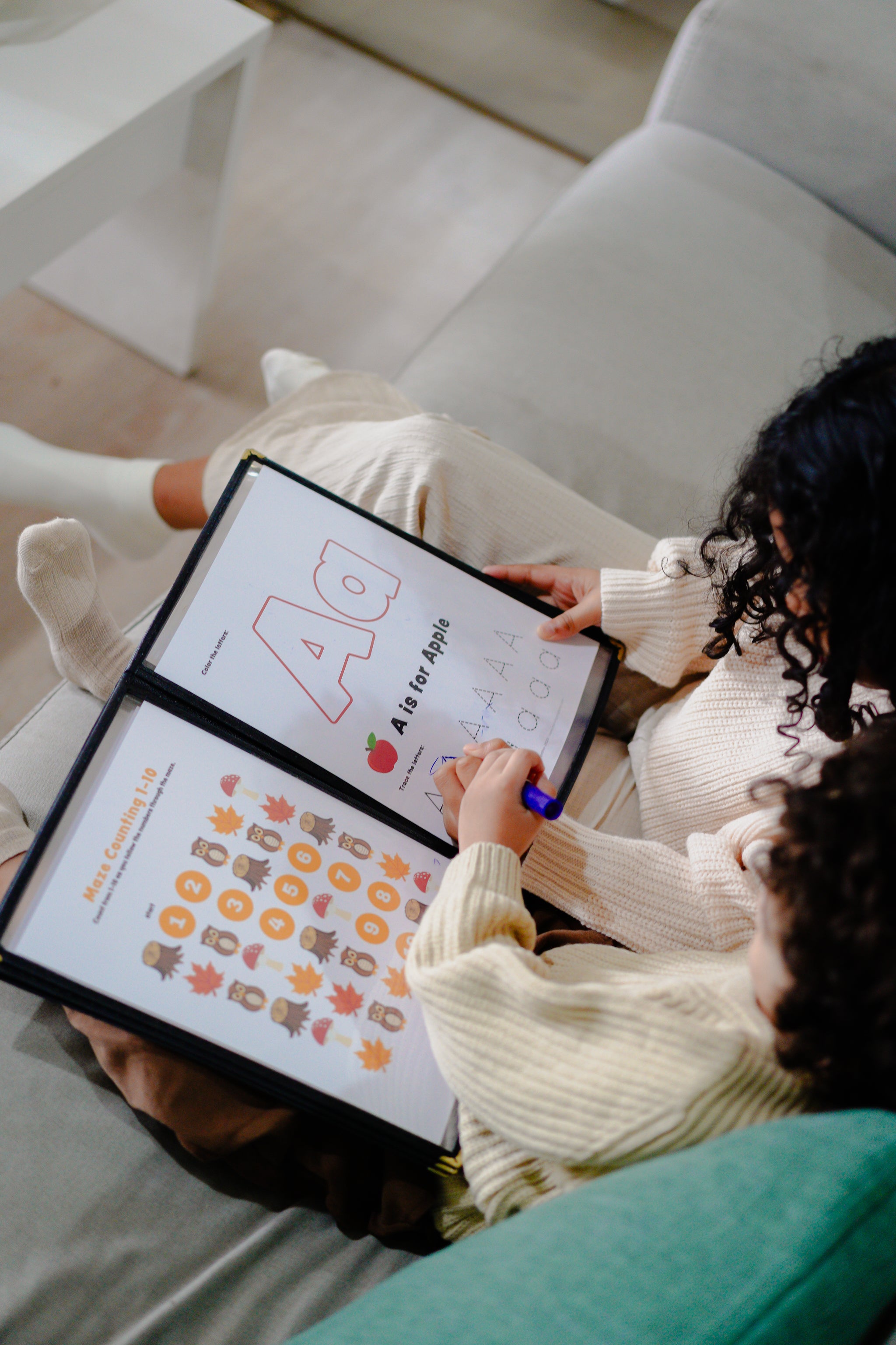 Two people sitting on a couch looking at educational materials with colorful graphics.