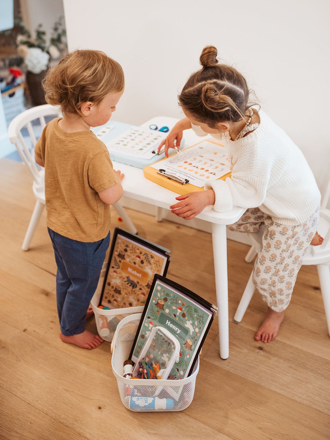 Two children playing with educational toys on a wooden floor.