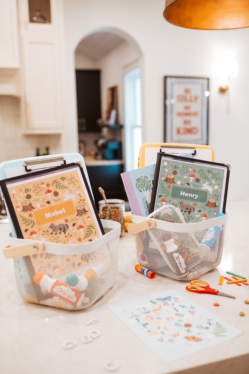 Children's name plates on a table with stationery items in a home setting