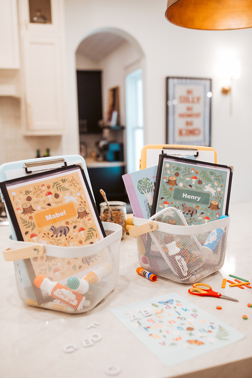 Children's name plates on a table with stationery items in a home setting